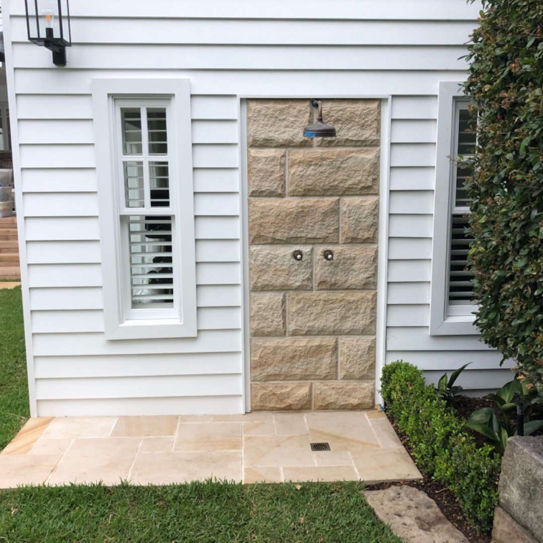 sandstone-outdoor-stone-shower-wall Sandstone clad outdoor shower wall with sandstone paving