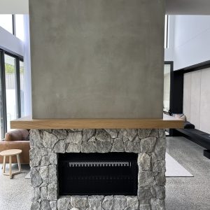 Grey natural stone fireplace cladding with timber mantel - Stone Cladding Sunshine Coast